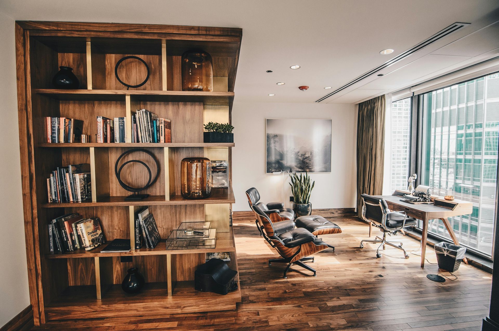 A living room with a wooden bookshelf and a desk.