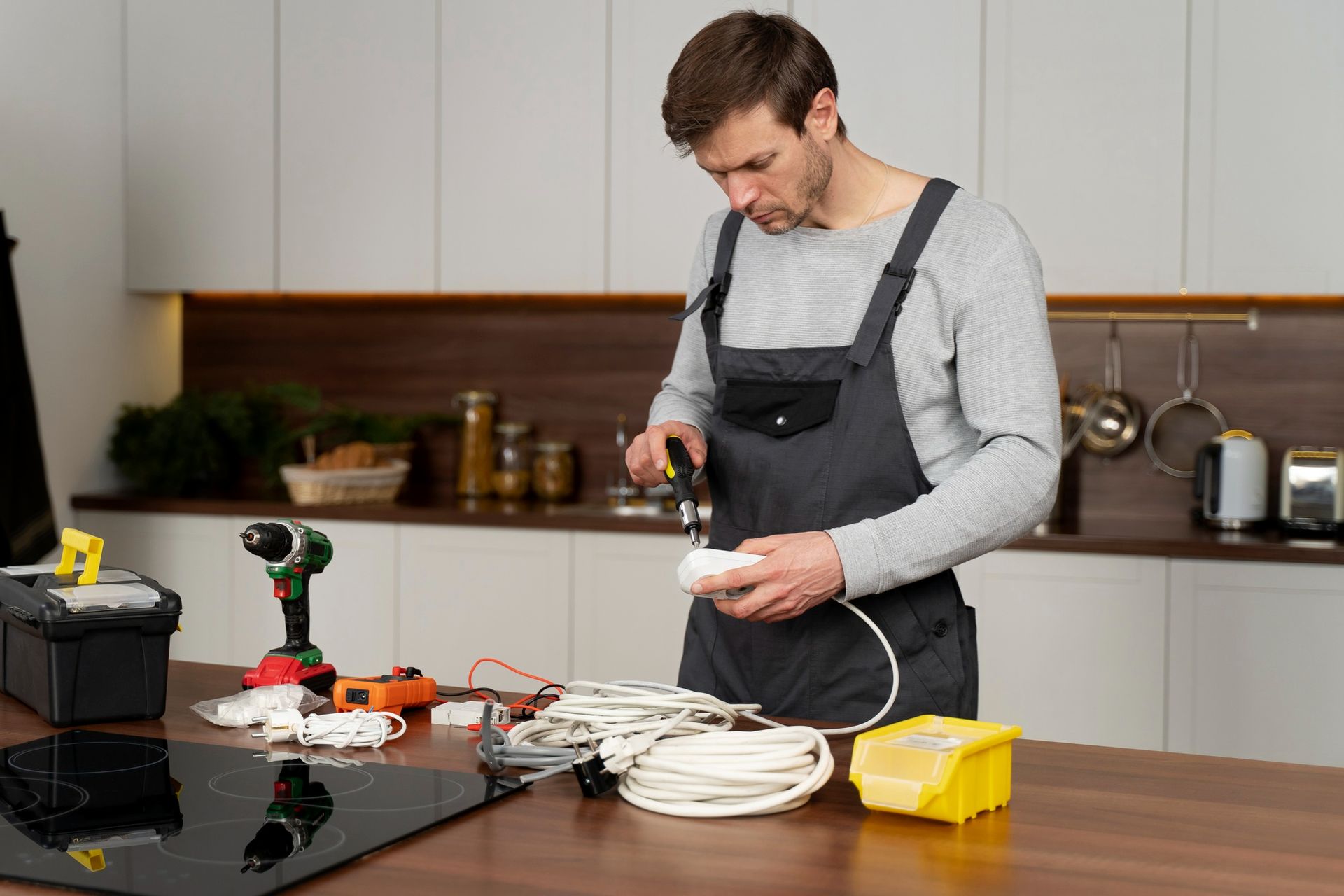 a man is working on an electric stove in a kitchen .