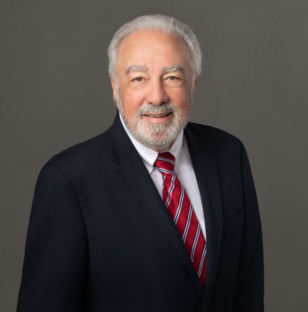 A man with a beard is wearing a suit and tie.