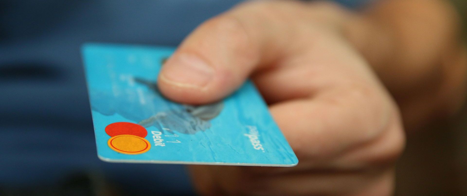 A person is holding a credit card in their hand.
