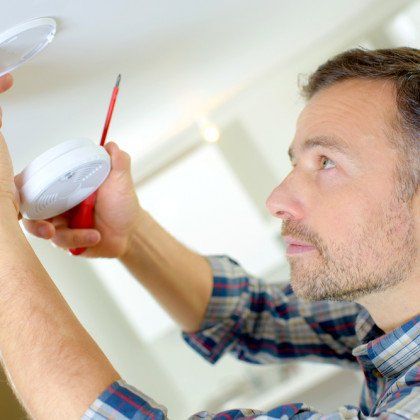 A Worker Who Inspects a Fire Alarm