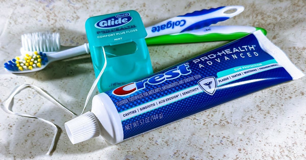 A tube of crest pro health advanced toothpaste next to a toothbrush and floss