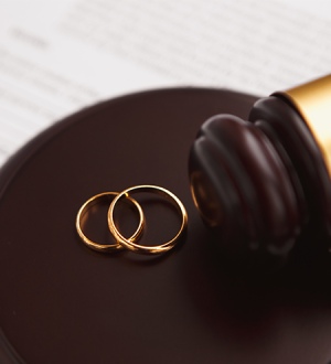 A pair of wedding rings on top of a wooden gavel