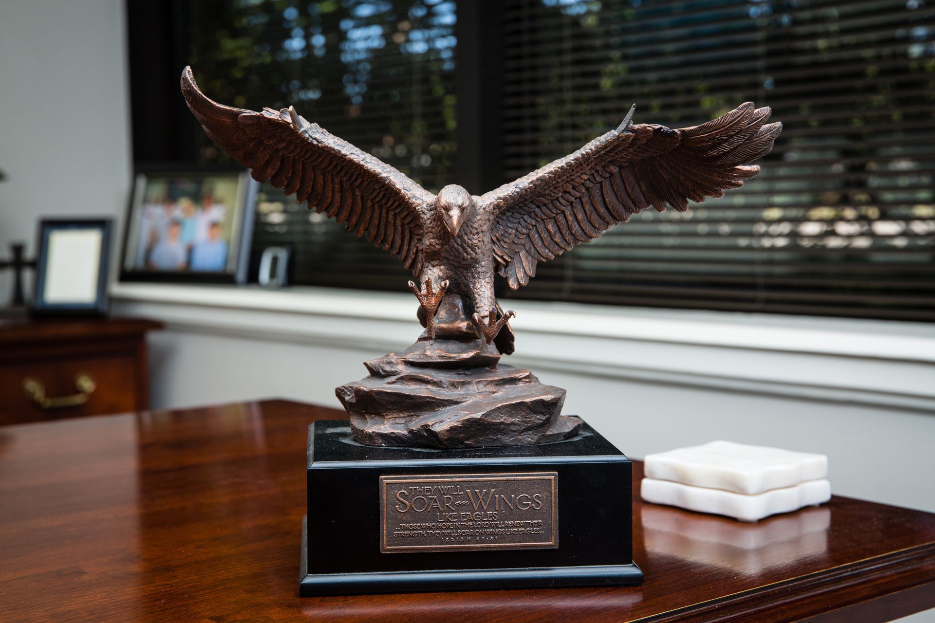 A statue of an eagle sitting on top of a wooden table.