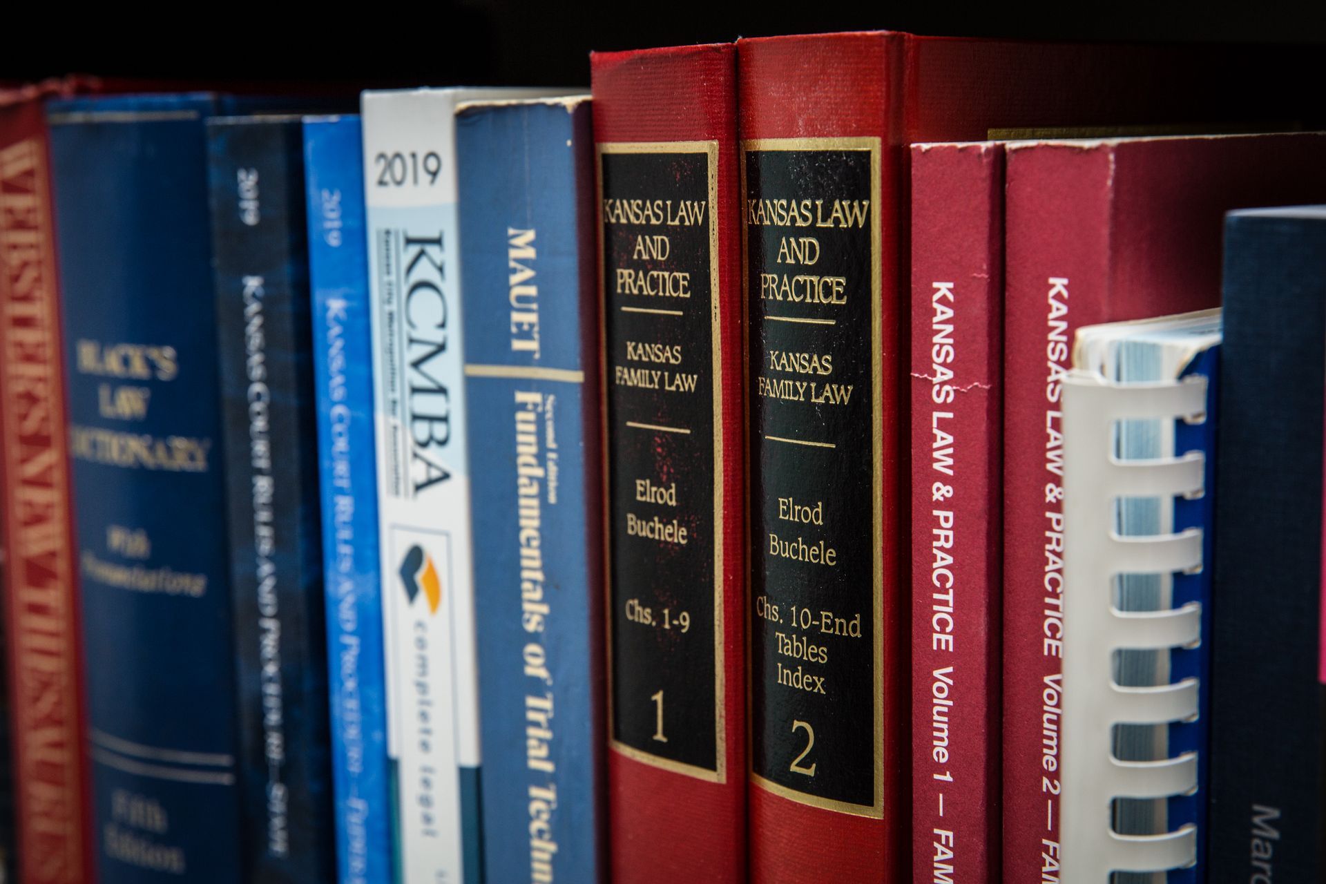 A row of books on a shelf including one titled kansas law & practice