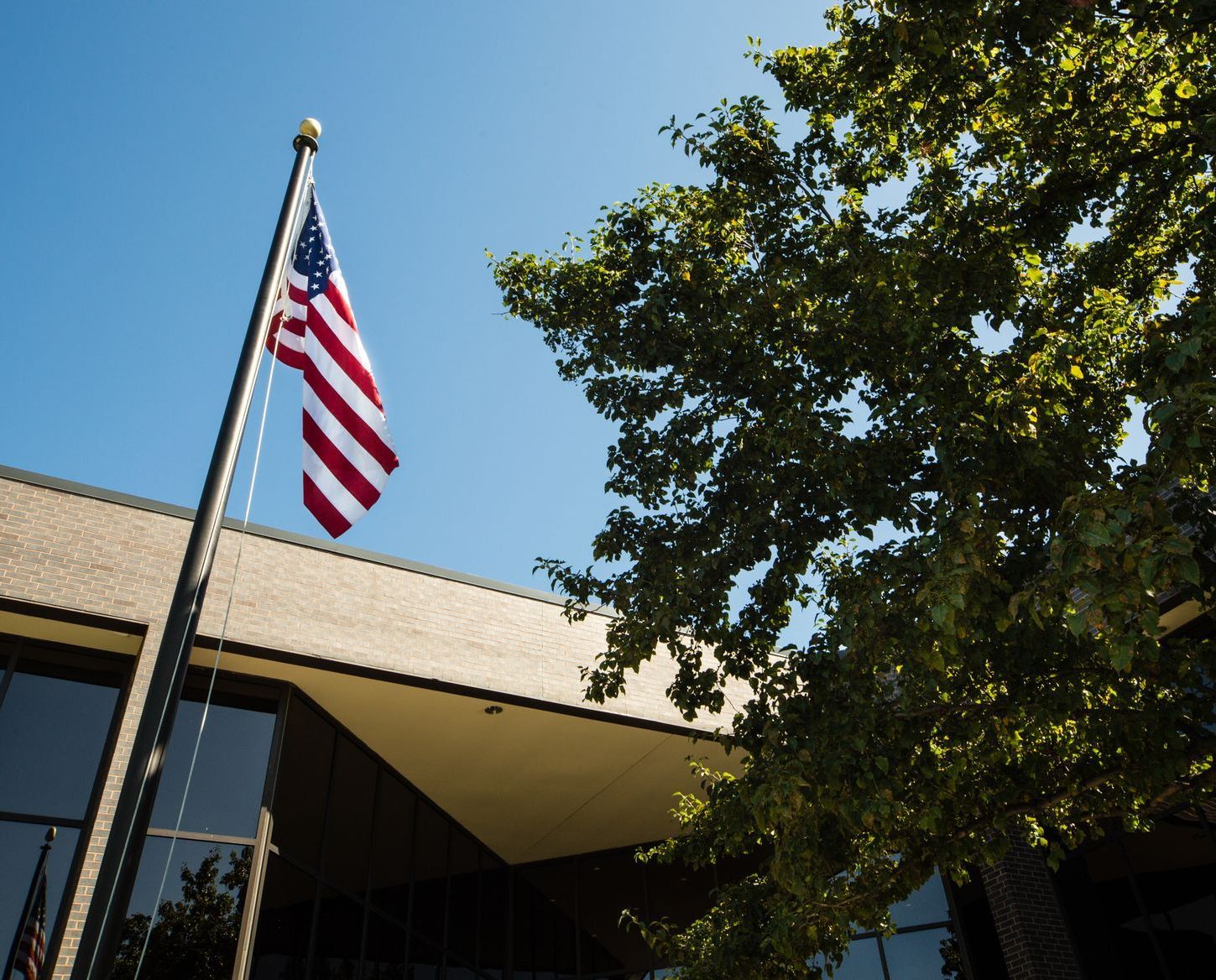 An american flag is flying in front of a building