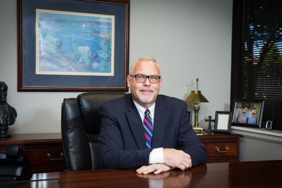 A man in a suit and tie is sitting at a desk.