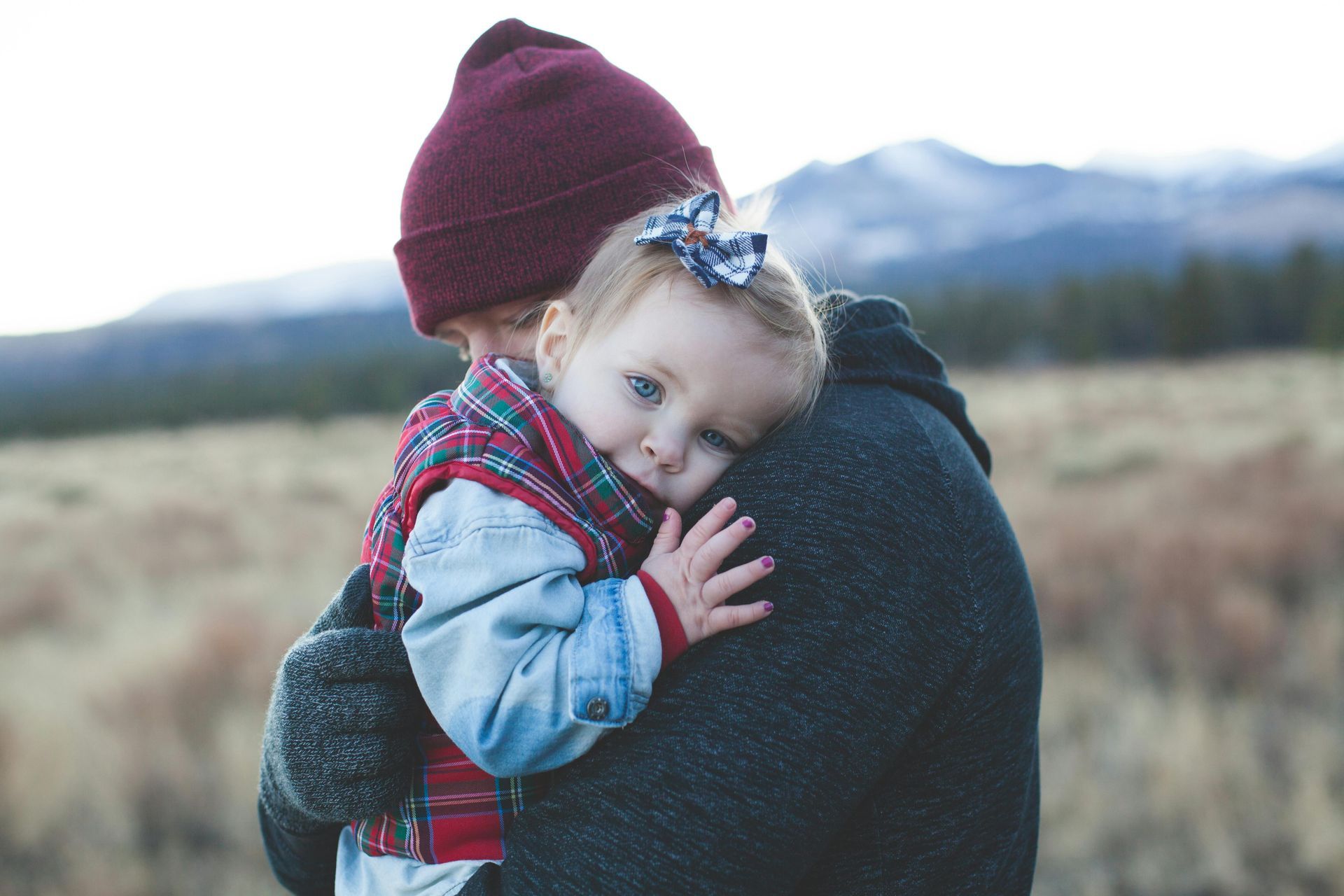 A man is holding a little girl in his arms.