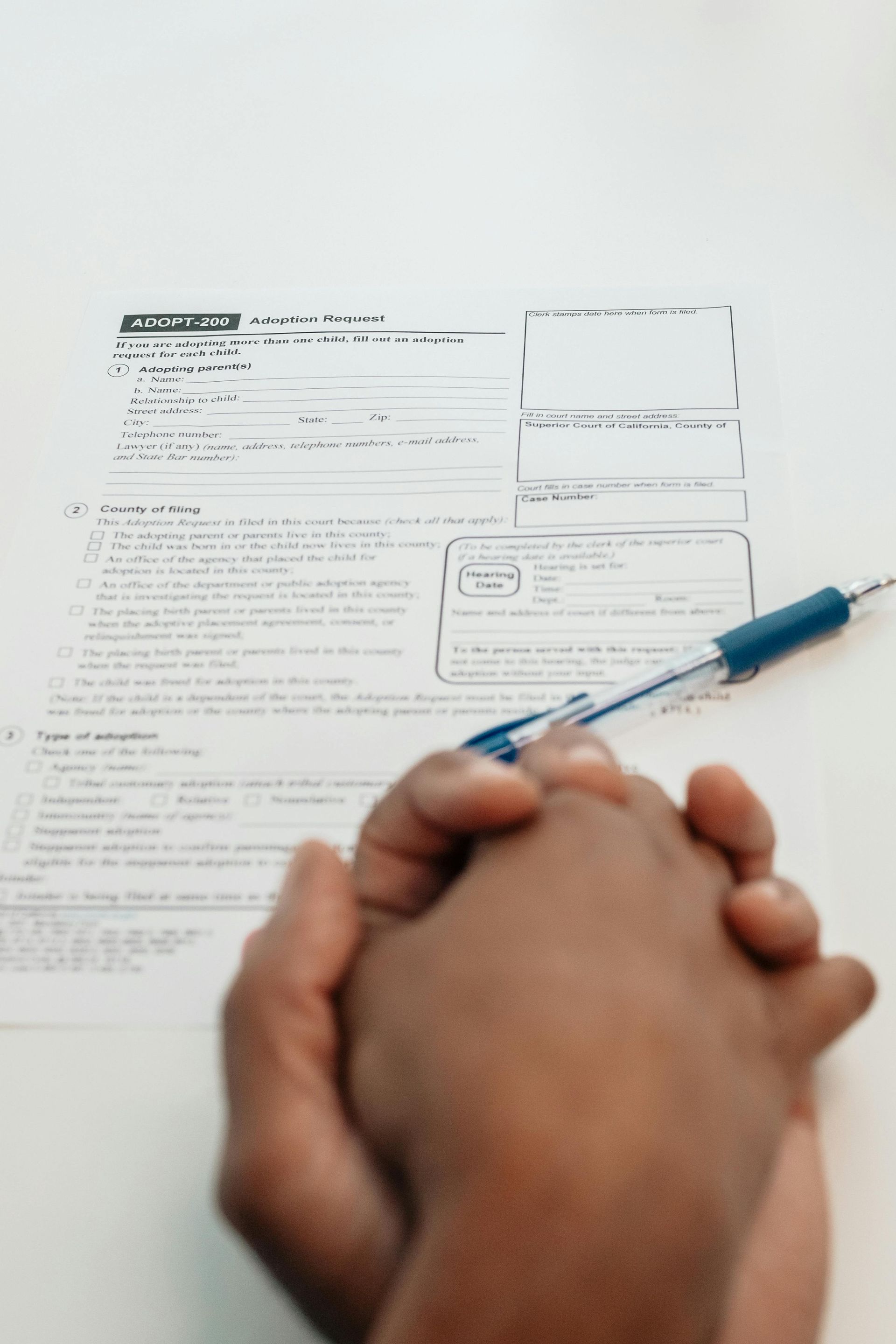 A person is holding a pen over a piece of paper.