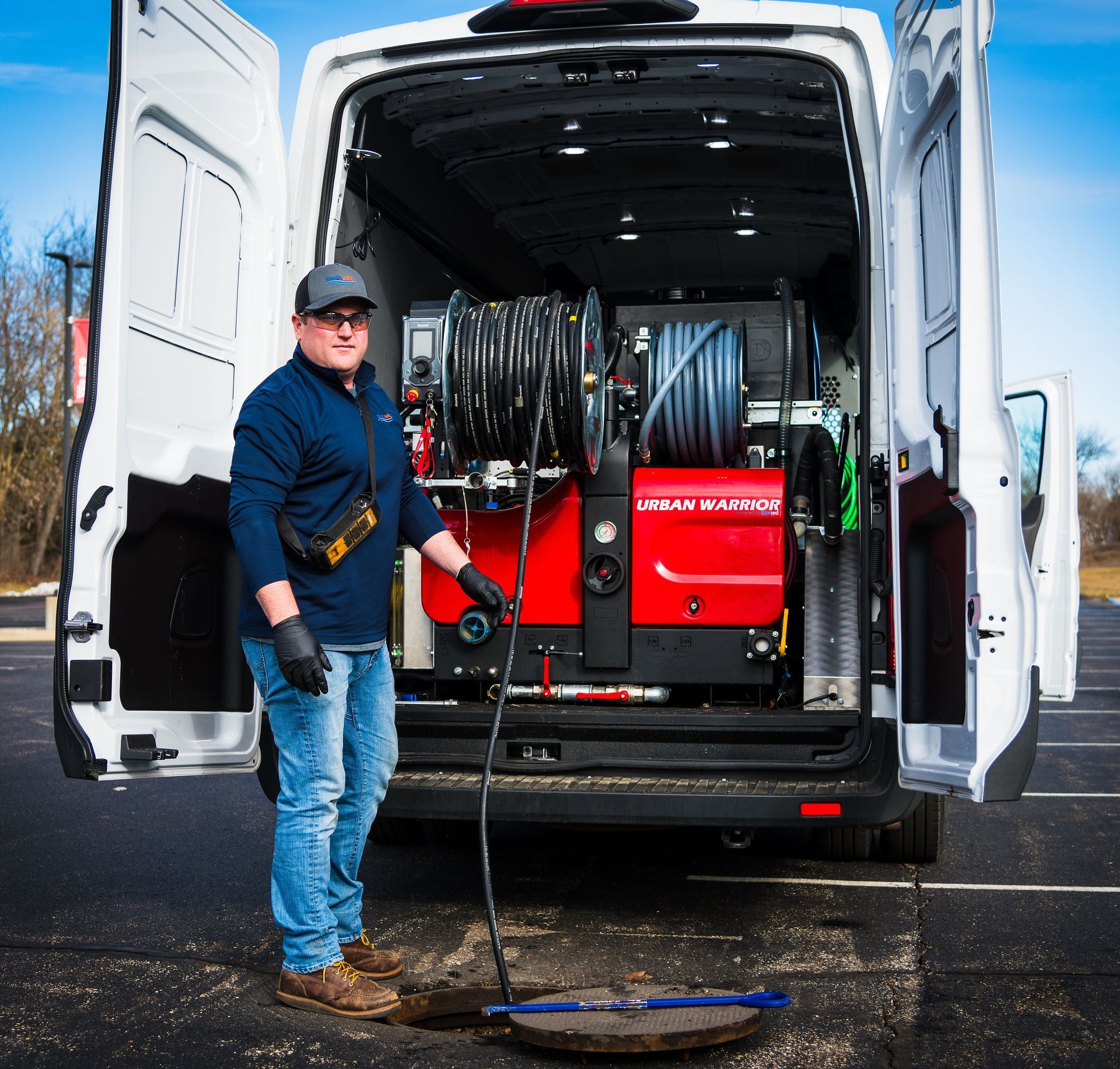 A man is standing in front of a van with the door open