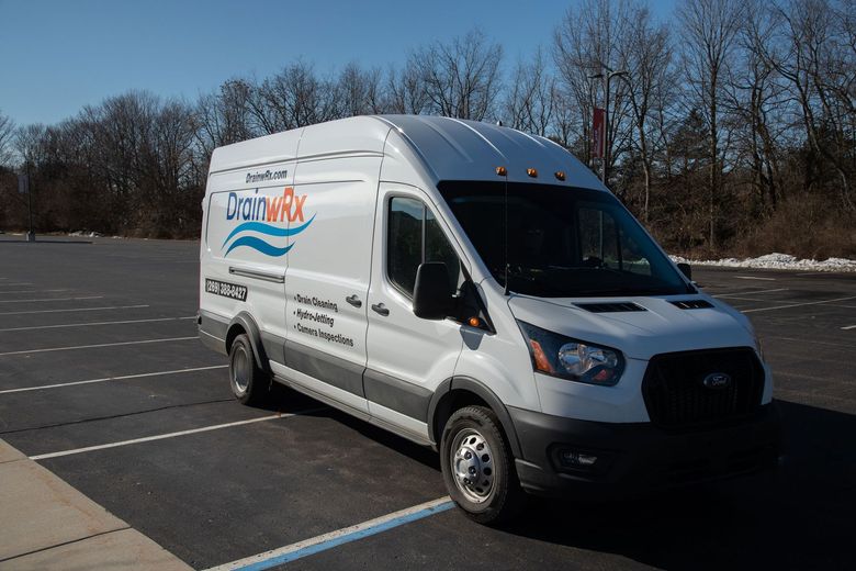 A white van is parked in a parking lot.