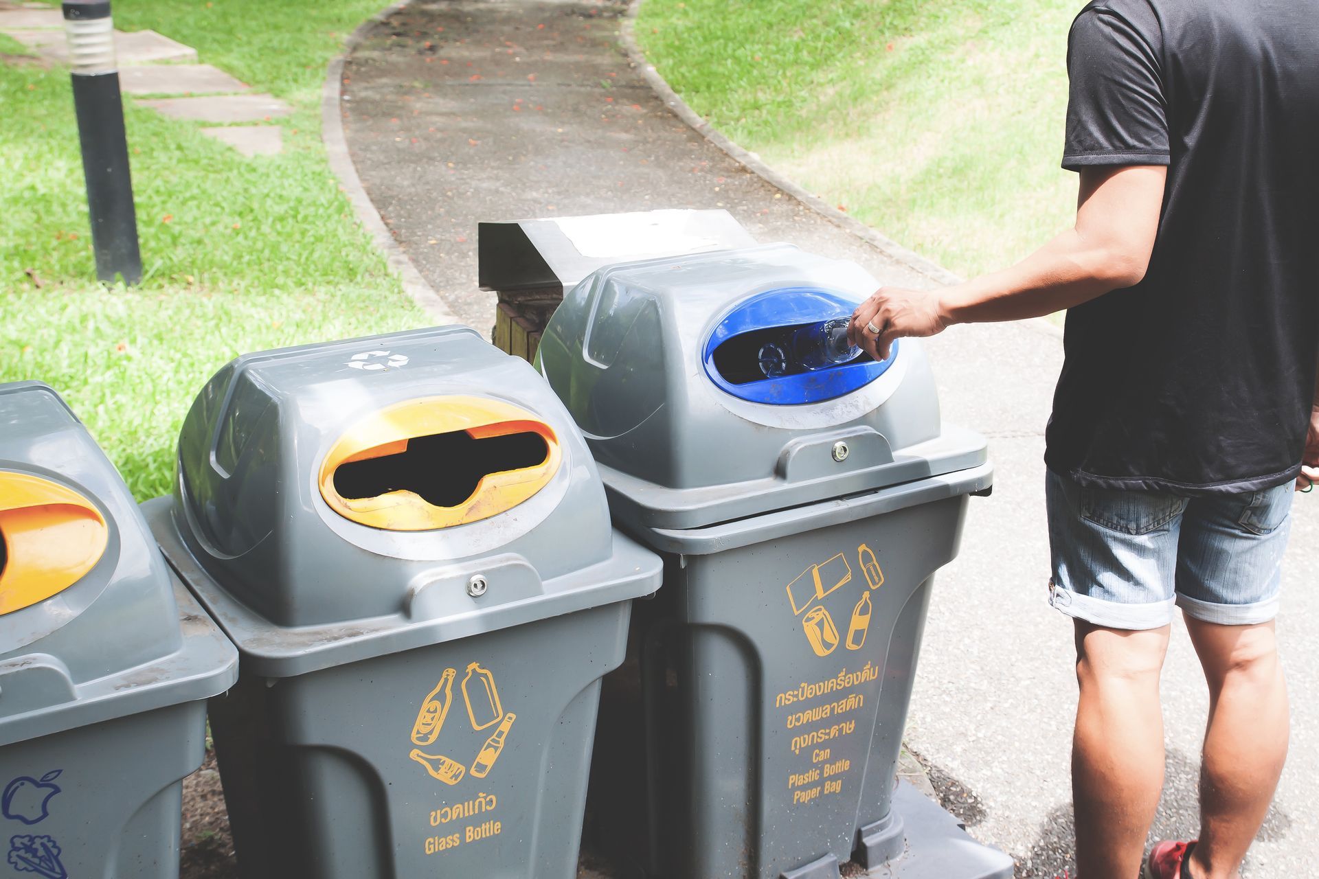 Man throws plastic bottle into recycling bin