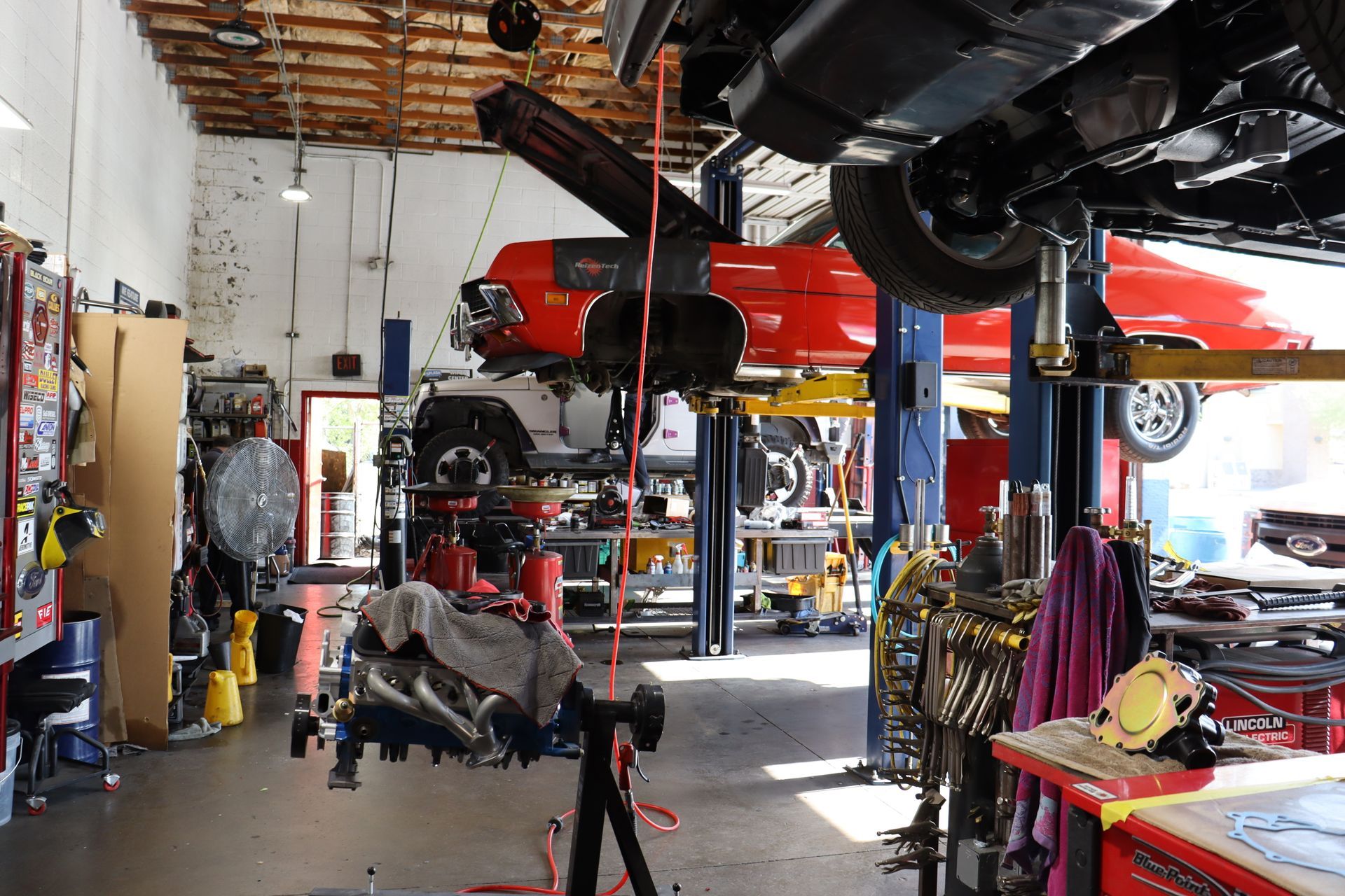 A Red Car Is Being Worked on in a Garage | Copperstate Auto And Fleet