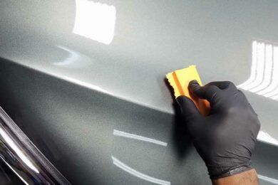 Une personne répare une prise électrique avec un tournevis.