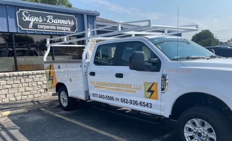 A white truck is parked in front of a building.