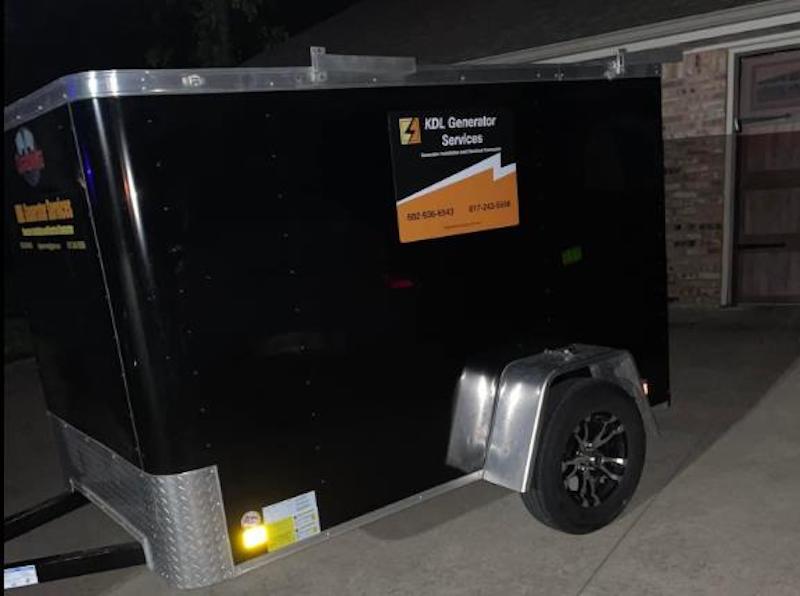 A black trailer with a sticker on it that says fuel generator service