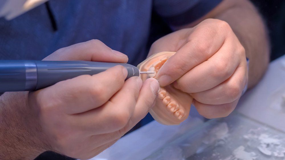 Dentist holding motor handpiece tool — Maitland Dental Care In Maitland NSW