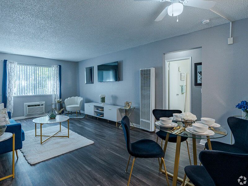 Living room in a modern apartment with a dining table, sofa, and a large window.