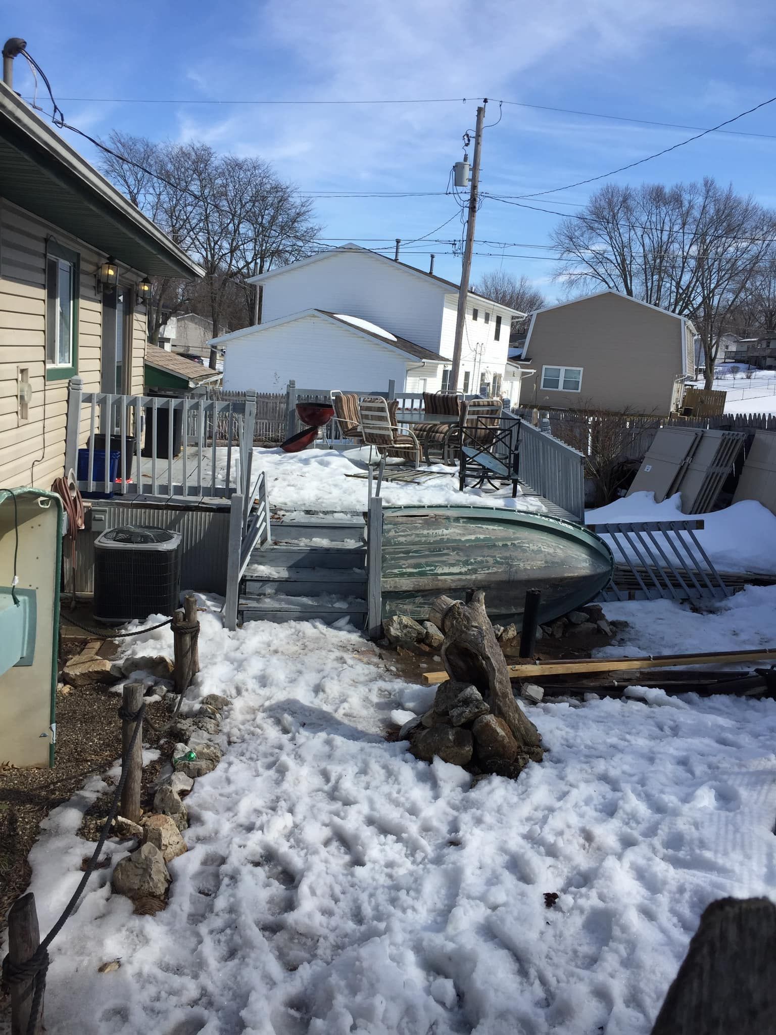 A snowy yard with a house in the background.