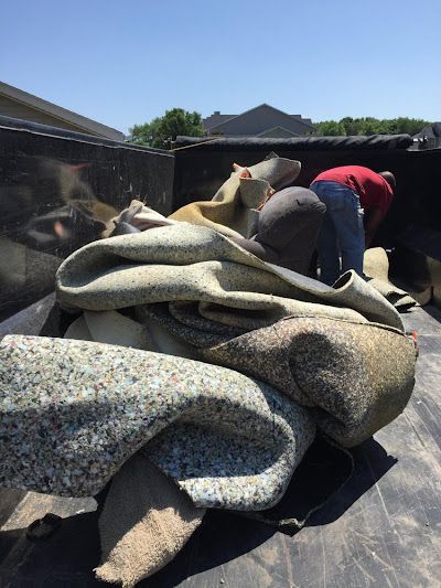 A pile of carpet is sitting in the back of a truck.