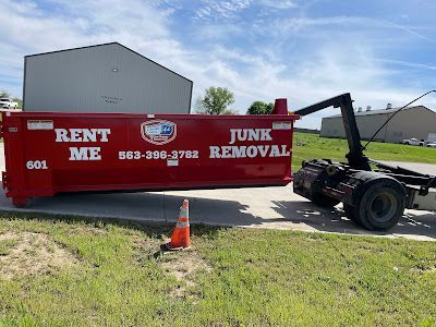 A red junk removal dumpster is parked on the side of the road.