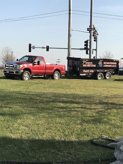 Two red trucks are parked next to each other in a grassy field.