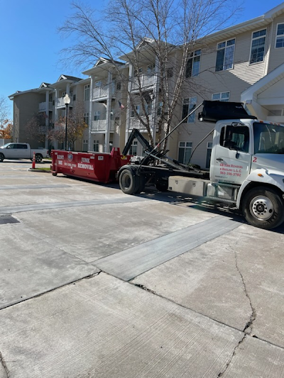 A dump truck is parked in a parking lot in front of a building.