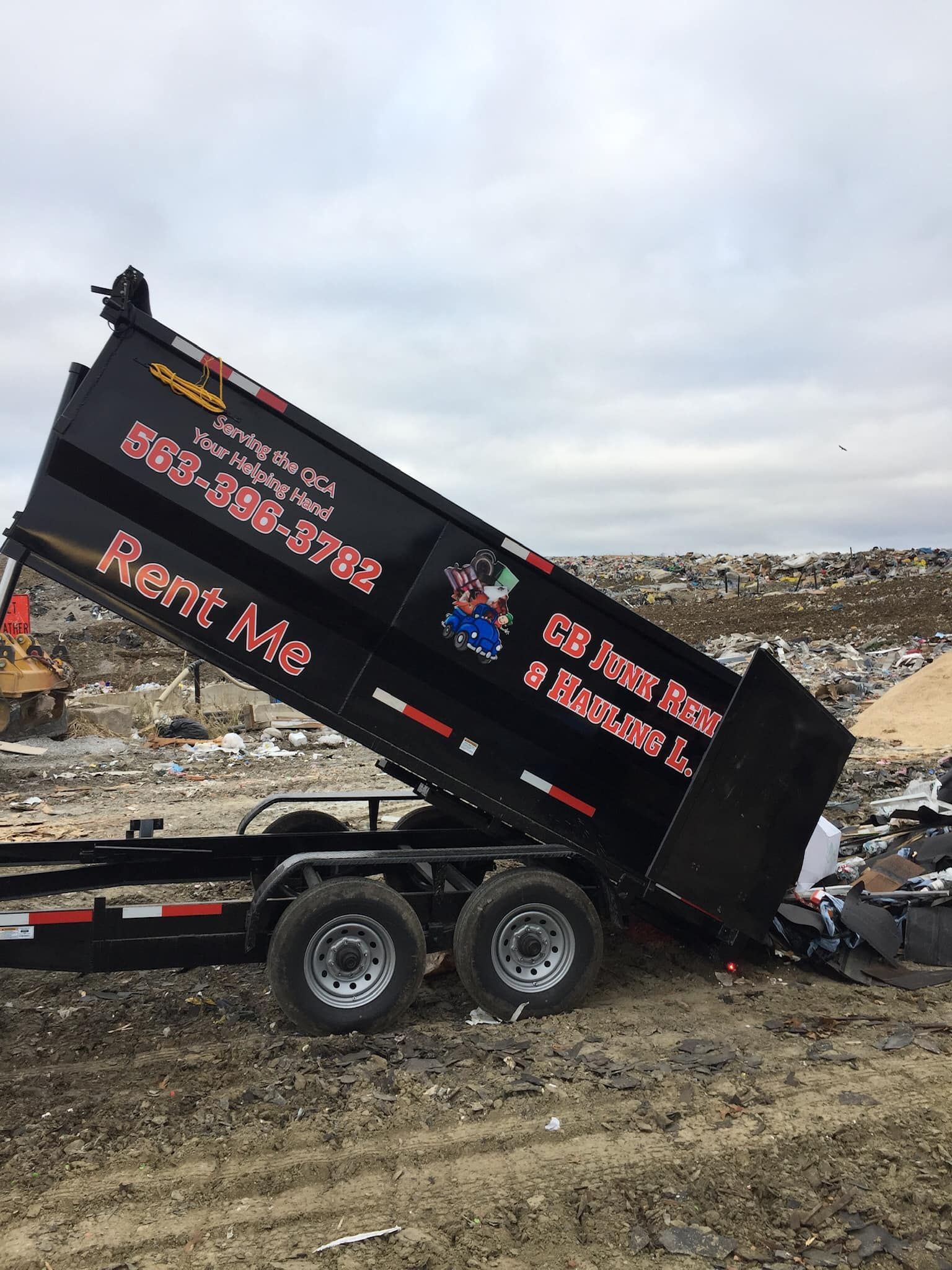 A dump truck is sitting on top of a dirt field.
