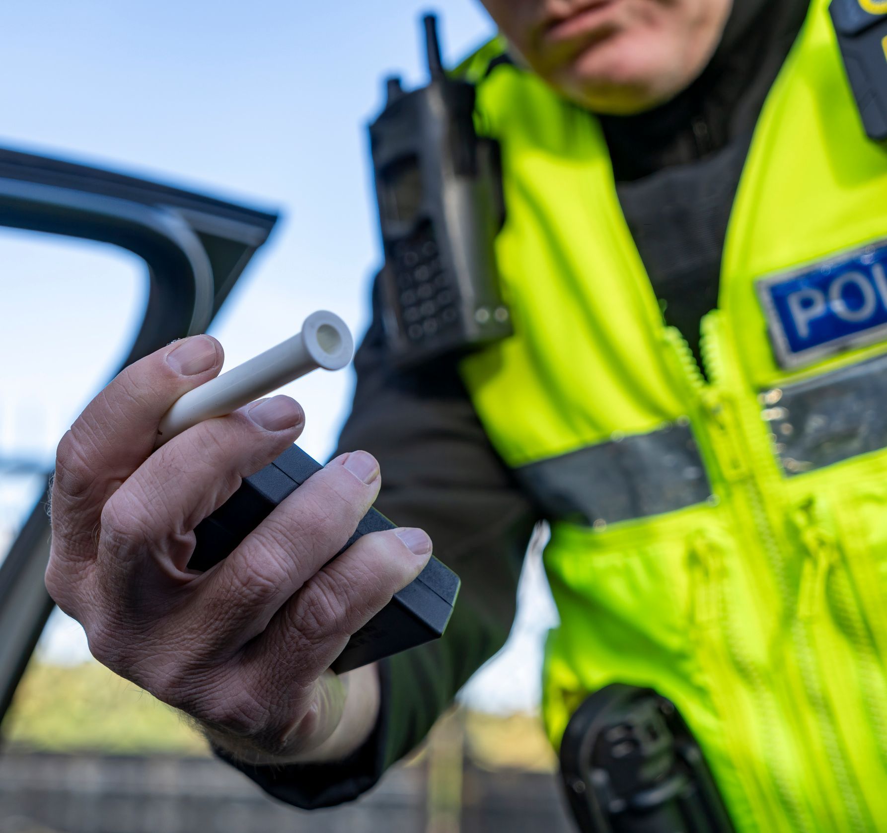 A man in a yellow vest with the word police on it