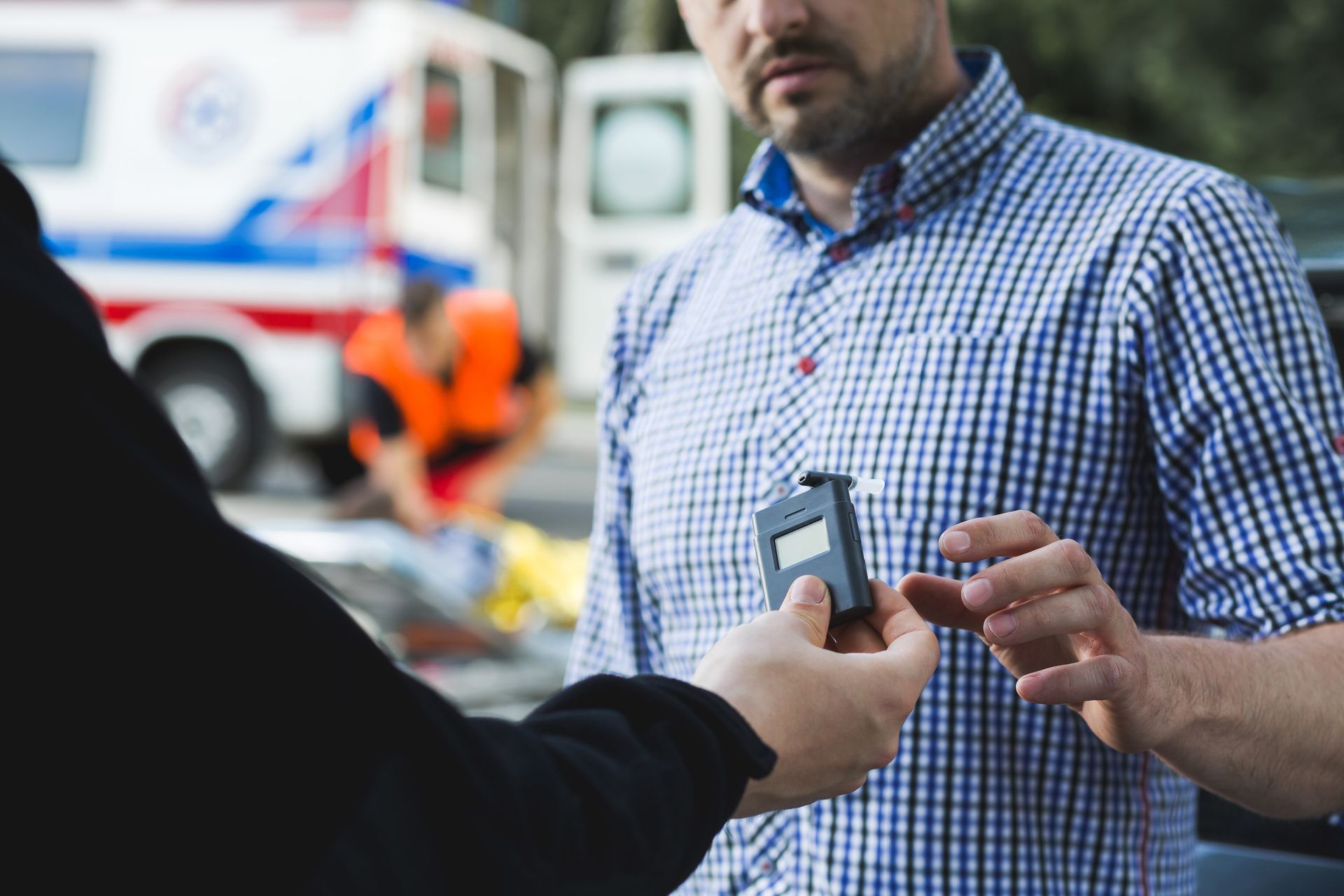 A man is being tested for alcohol by a police officer.