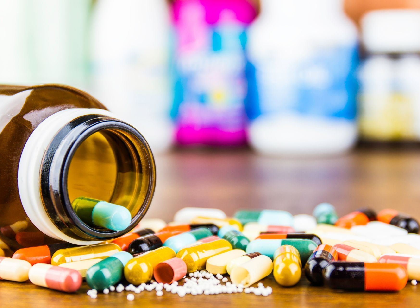 A bottle of pills is spilling out of it on a table. A bottle of pills is spilling out of it on a table.