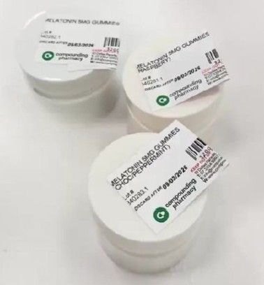 Three white containers of melatonin gummies, each labeled with product information and a barcode.