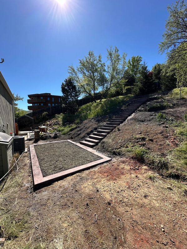 A staircase is going up a hill in a backyard.