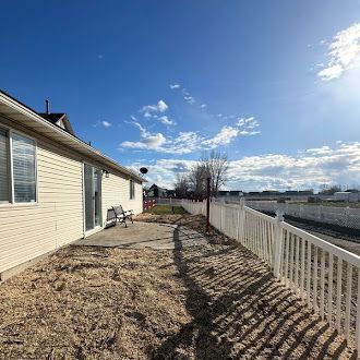 A house with a white fence and a bench in front of it.