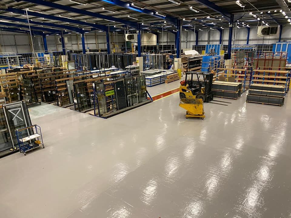 Industrial floor coating – high-gloss grey epoxy base with red walkway & yellow safety lines applied for heavy-duty traffic 