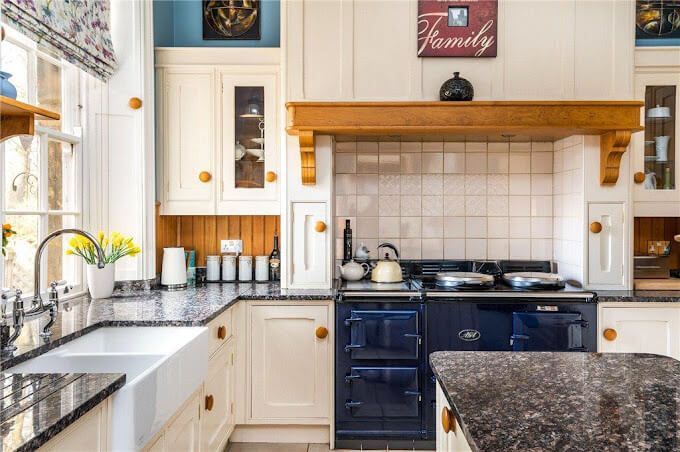 Restored period kitchen in soft blue – breathable paint preserves beams and range cooker for timeless family elegance