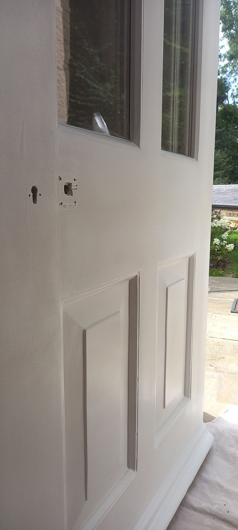 Careful repair and priming during door maintenance – holes patched and levelled, preserving authentic moulding