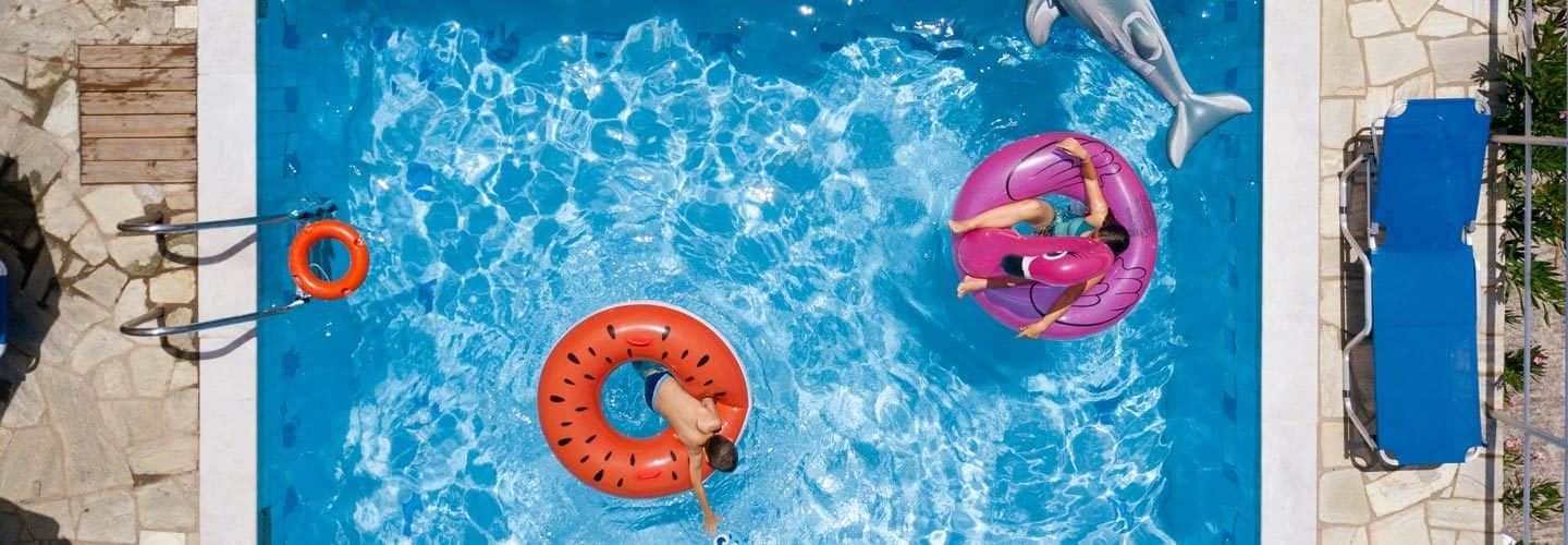 People floating on pool floats in pool