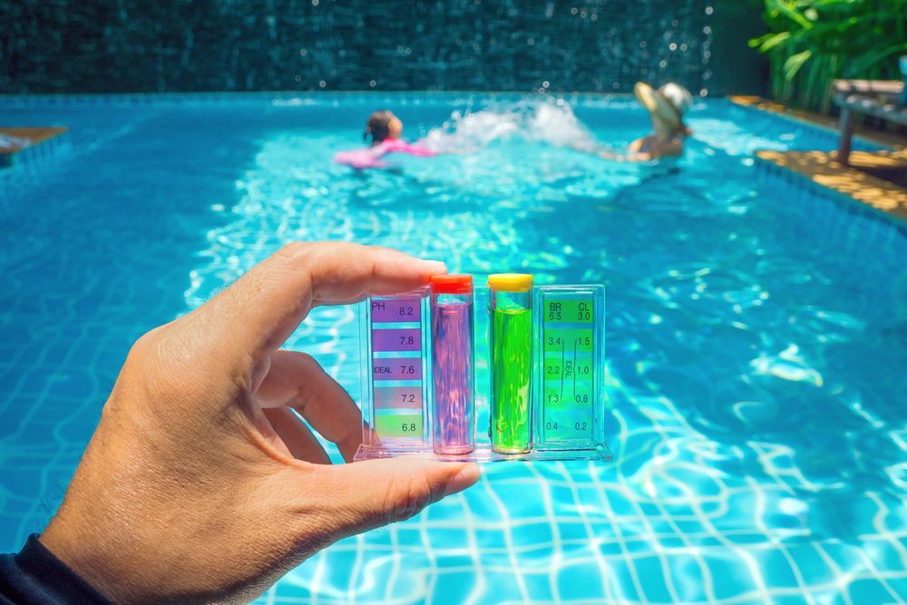 Pool chemical kit with people in pool in the background