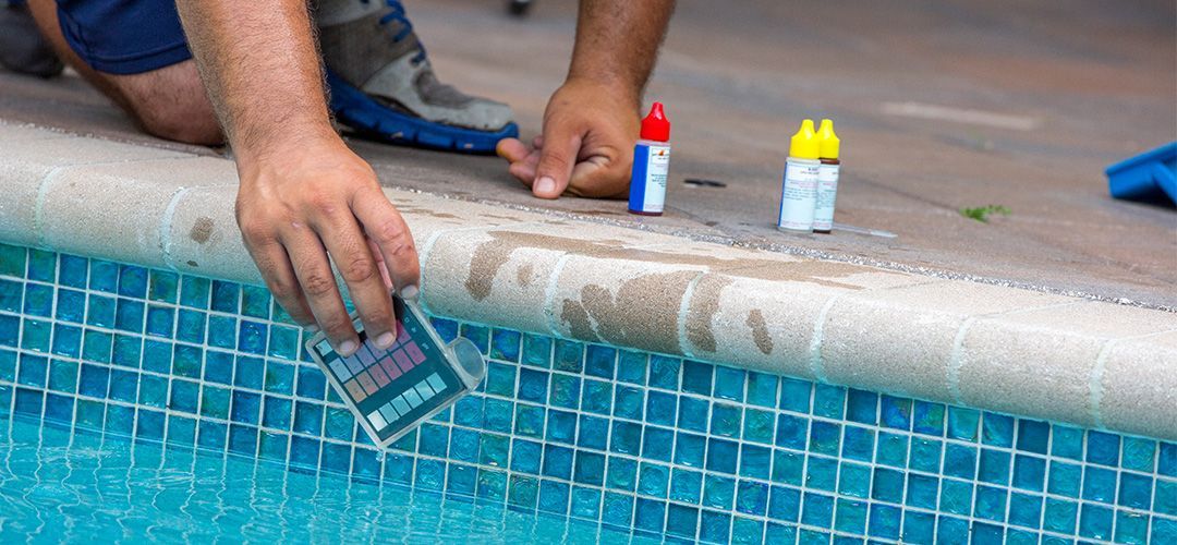 Pool professional testing water chemistry in pool