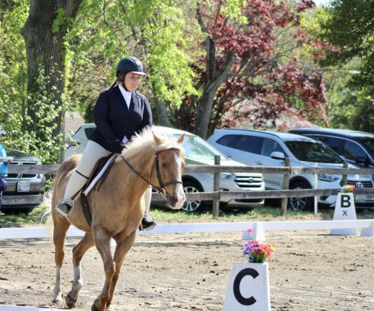 A woman is riding a horse in a circle with the letter c on it