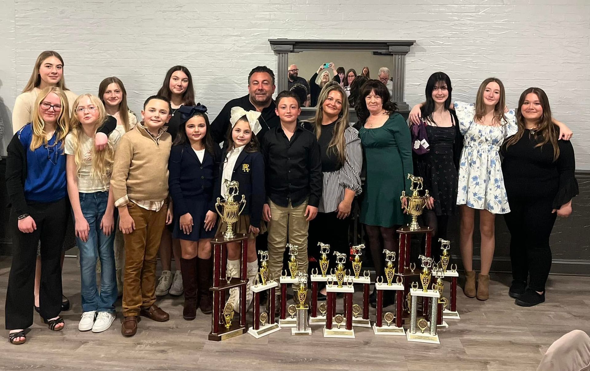 A group of people are posing for a picture with trophies.