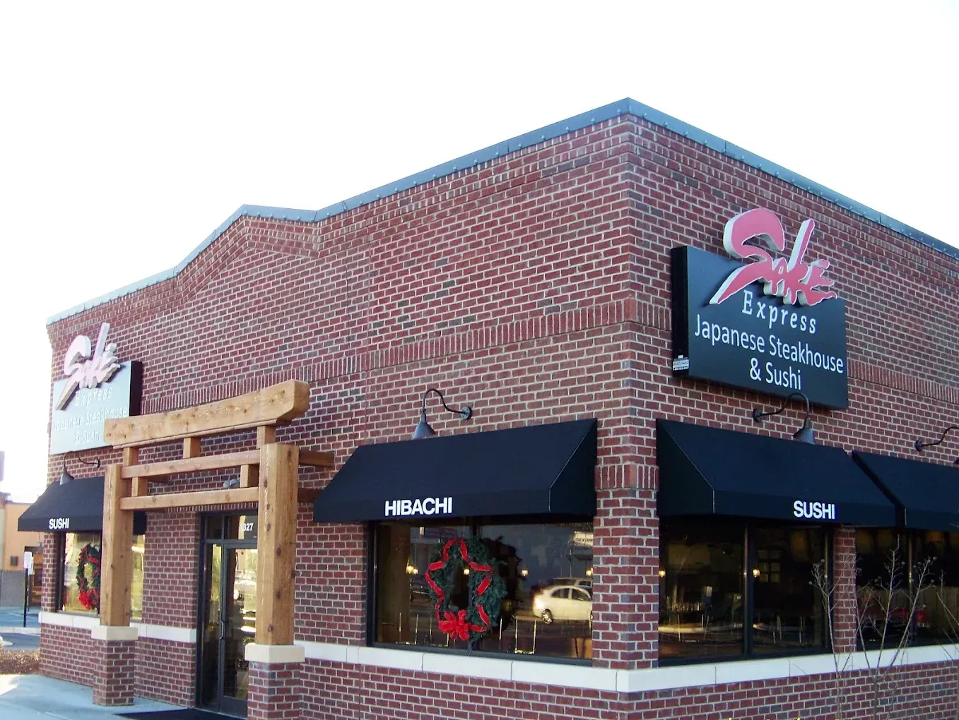 Brick storefront with black awnings and sign for a flower shop at a street corner
