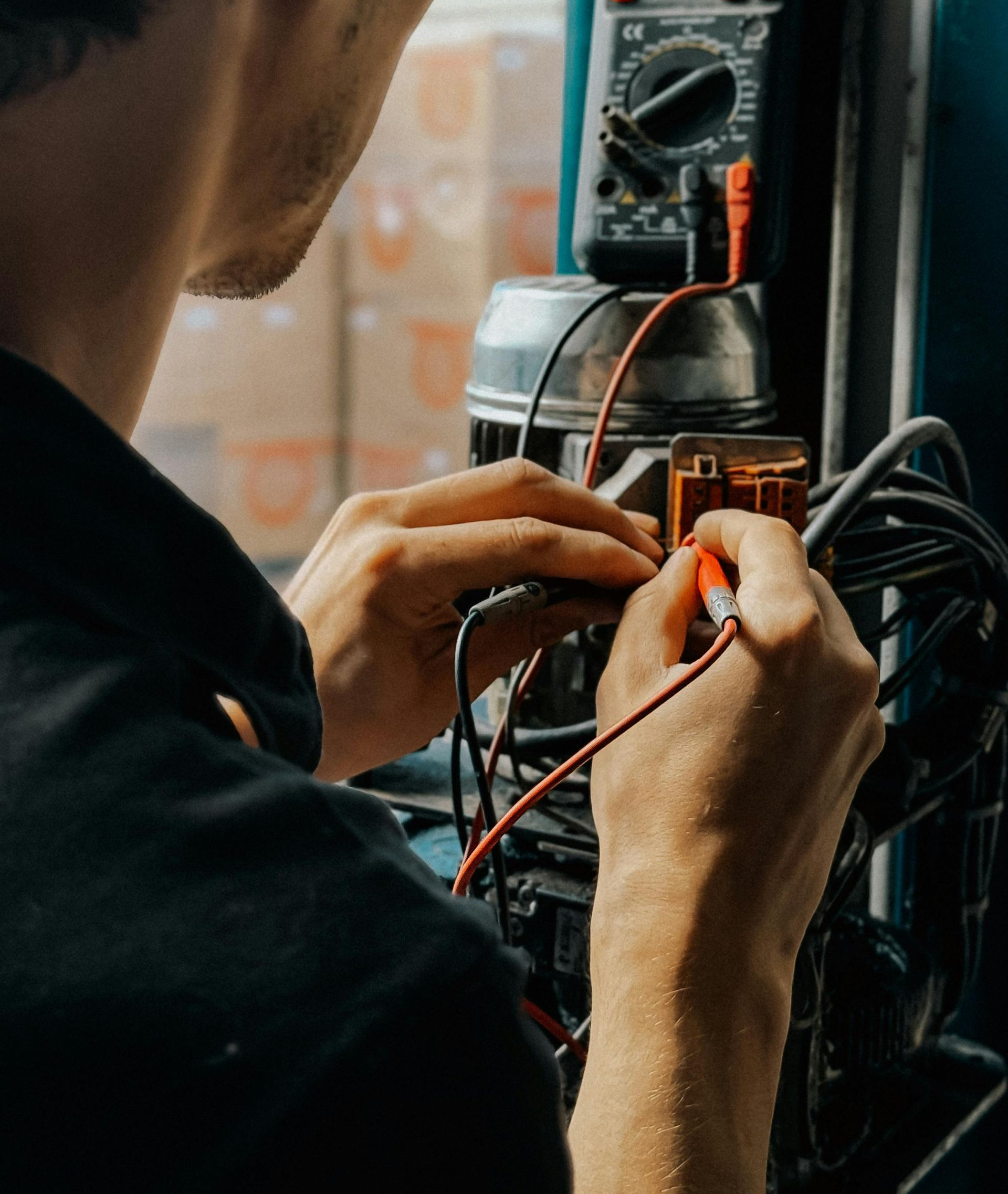 A technician uses a multimeter to test electrical components on a piece of machinery.