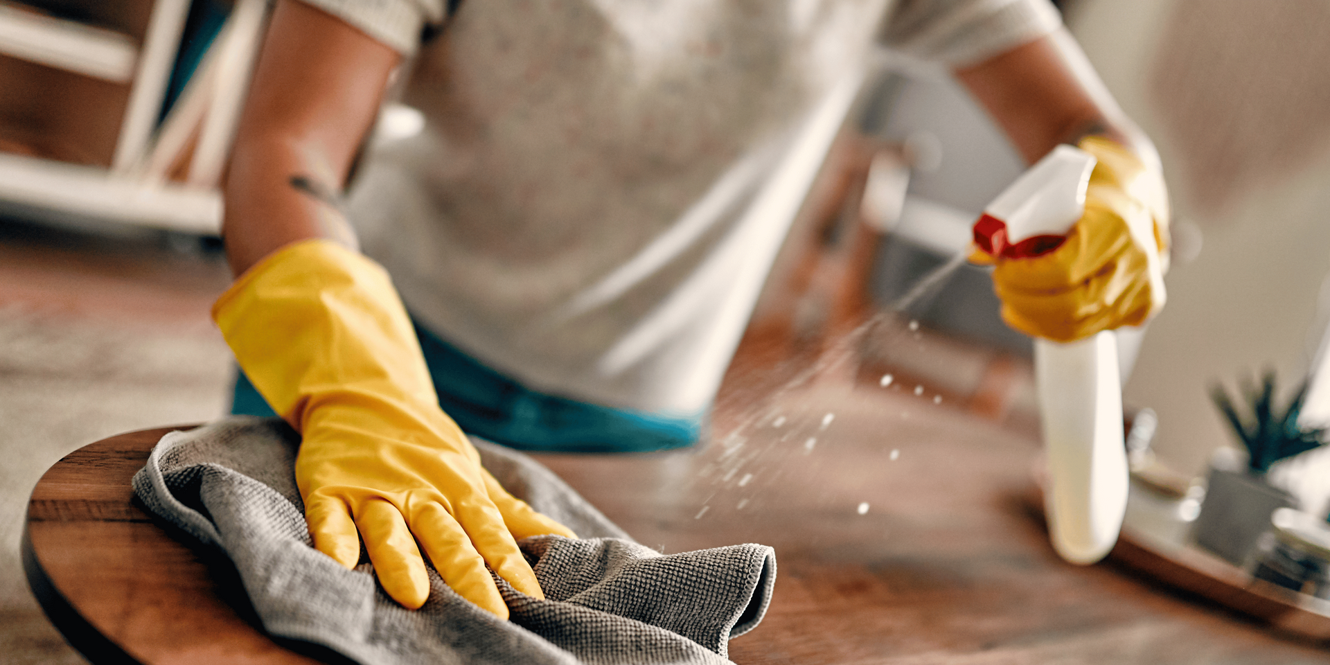 Person in a hazmat suit standing next to industrial equipment in a room sealed with plastic. Other people in the background.