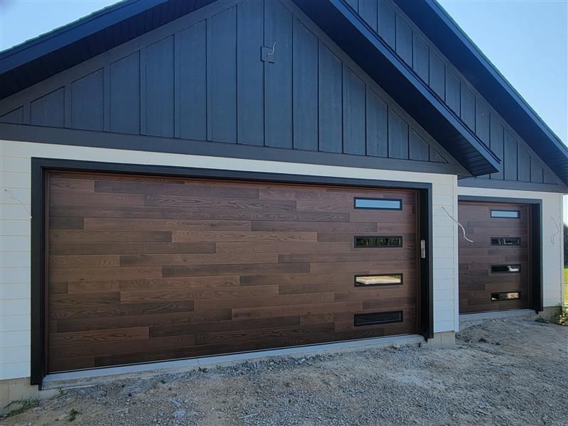 A white garage door is open in a parking garage.
