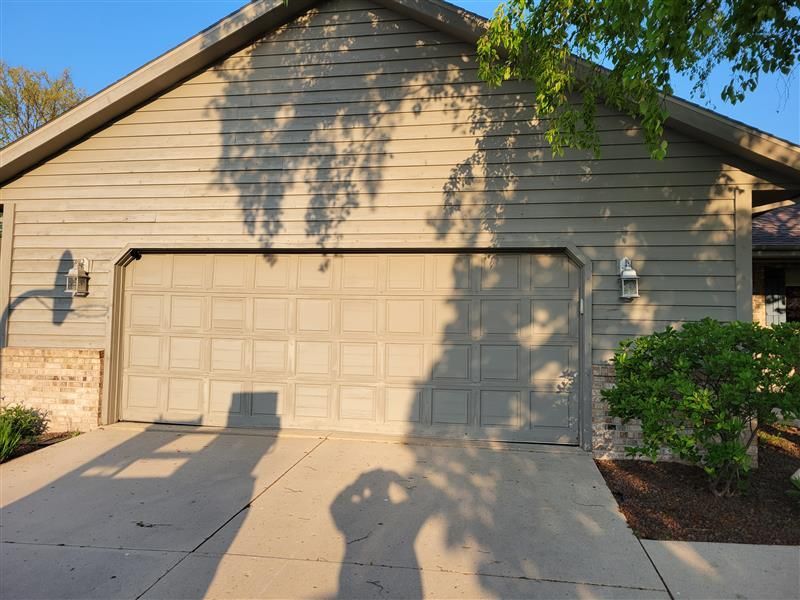 A house with a blue garage door and a brown roof.