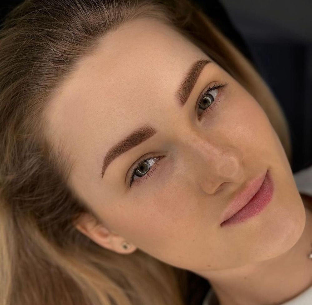 A close up of a woman 's face with a smile on her face.