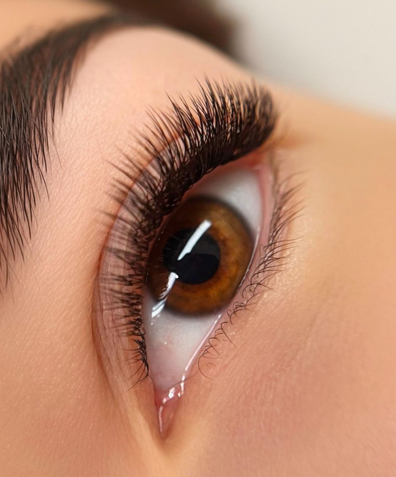 A close up of a woman 's eye with long eyelashes.