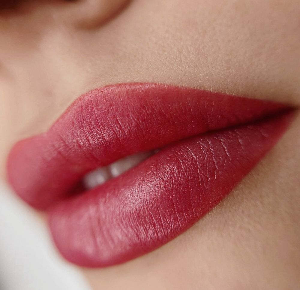A close up of a woman 's lips with red lipstick.